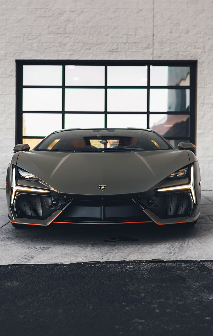 Matte‑finished sports car parked in front of a glass garage door, showcasing the smooth, non‑glossy look achievable with matte paint protection film. 