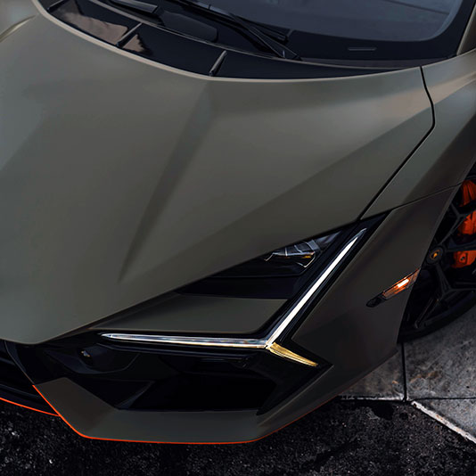 Top-down view of the hood and headlight of a matte-finished sports car
