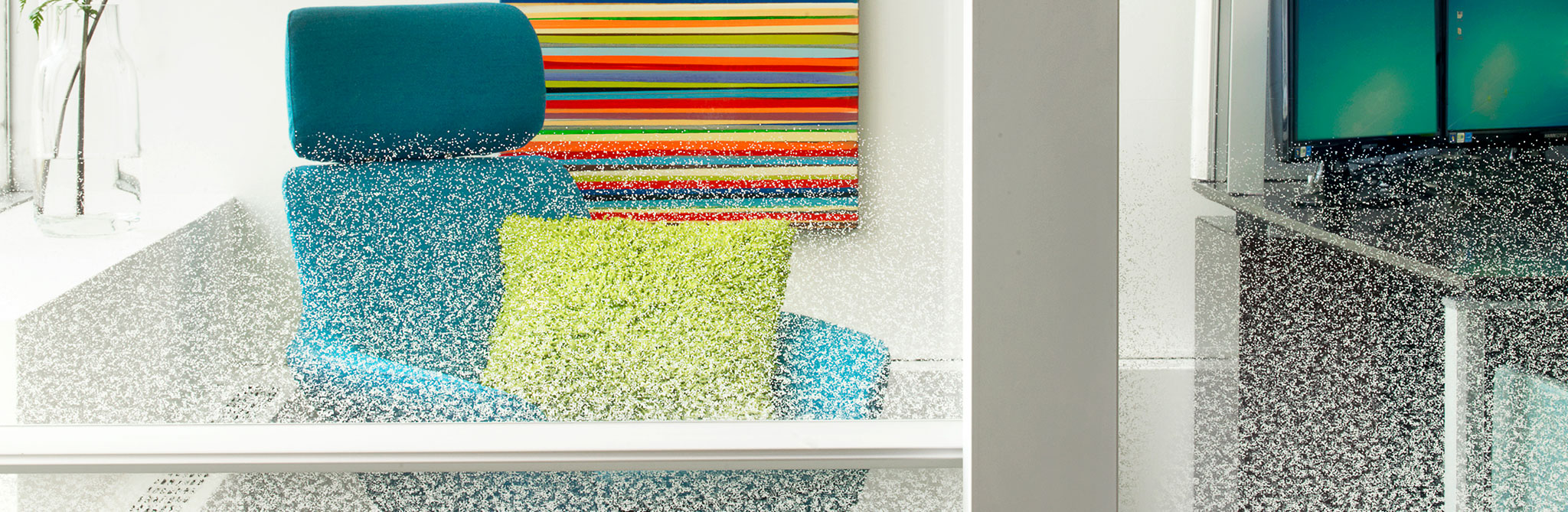 Blue lounge chair with a bright green pillow, partially obscured by textured frosted glass, with a colorful striped artwork on the wall behind it. 