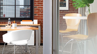 Office with a brick wall and frosted glass partition beside a desk.