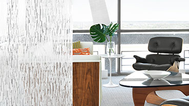 Modern living room partially obscured by a patterned frosted glass panel.