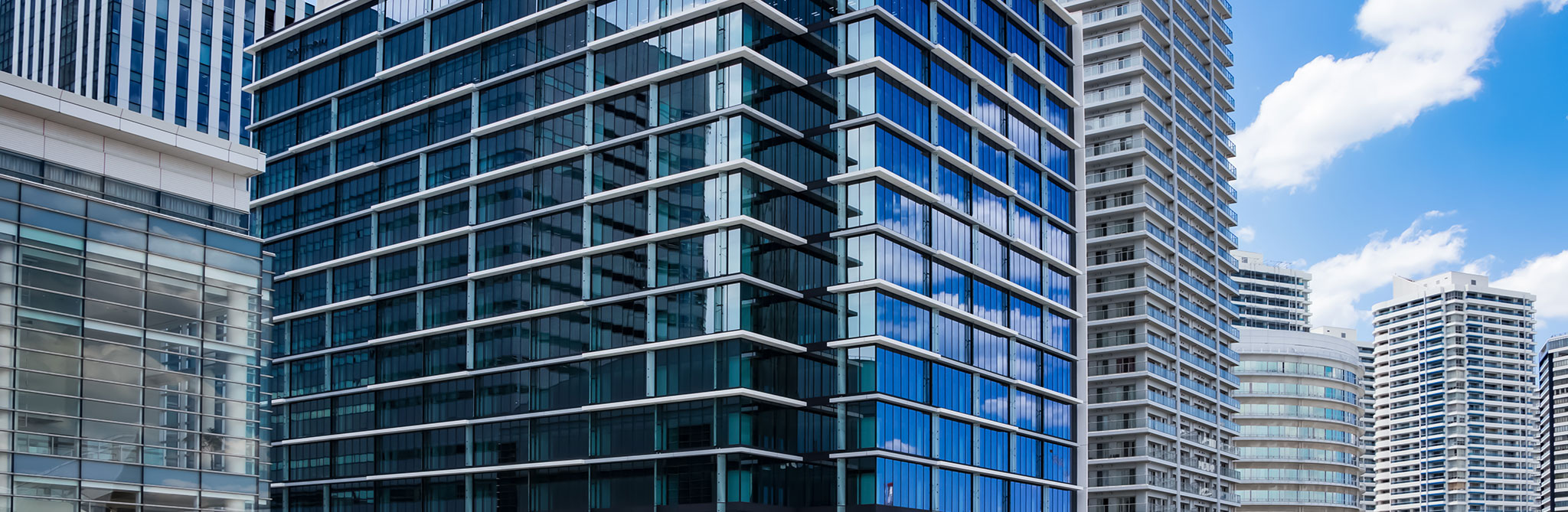 Tall modern building with blue‑tinted glass windows. 