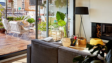 Modern living room opening to a sunny outdoor patio with seating.