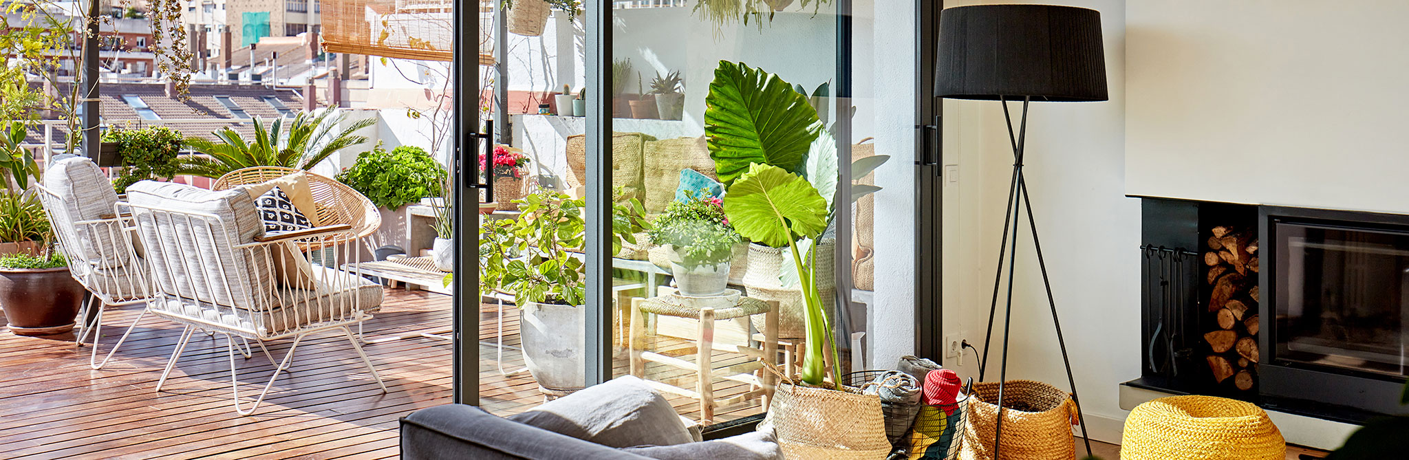 Modern living room opening to a sunny outdoor patio with seating. 