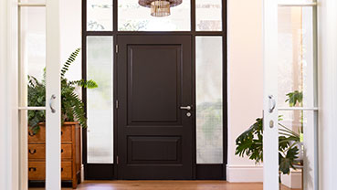 Entryway with a dark front door and frosted sidelights